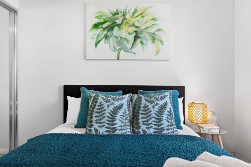 a bedroom with a bed with a blue comforter and pillows at Stylish Corporate Stay with Wi-Fi & Parking in Rockingham