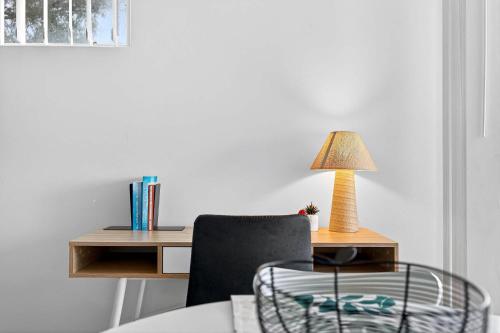 a room with a desk with a chair and a lamp at Stylish Corporate Stay with Wi-Fi & Parking in Rockingham