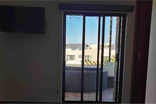 a sliding glass door with a view of a building at Casa de Campo Lake Shore Jocotepec in San Cristóbal Zapotitlán