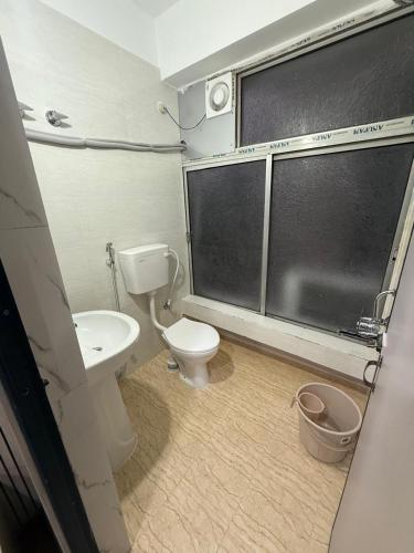 a bathroom with a toilet and a sink at Hotel Alohi Grand in Guwahati