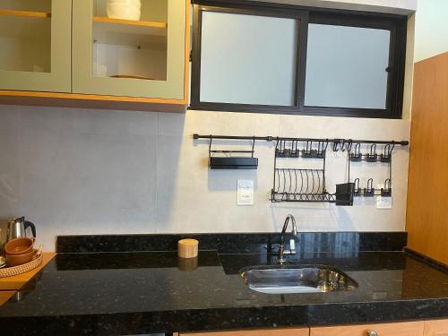 a kitchen counter with a sink and a window at Casa Mar III in João Pessoa