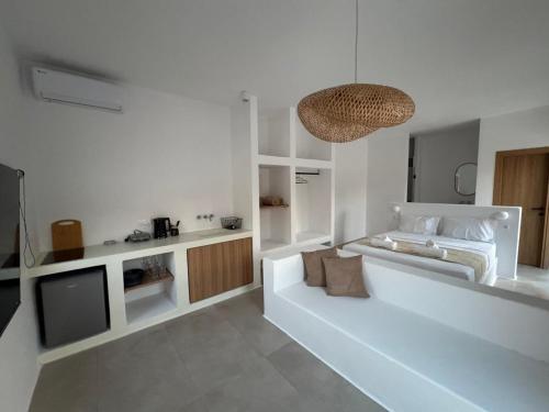 a white living room with a couch and a tv at Antiparos Gems in Agios Georgios
