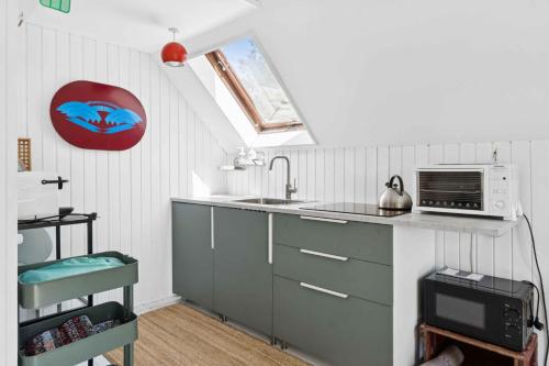 a kitchen with a sink and a microwave at Scenic Cottage Within Walking Distance To Beach in Nakskov
