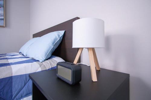 a lamp and a tv on a table next to a bed at Cozy Downtown London 1BR Gem in London
