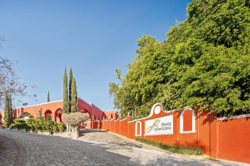 a orange fence with trees on the side of a road at Fiesta Americana Hacienda Ixtapan de La Sal in Ixtapan de la Sal