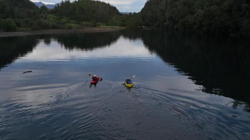 two people are standing in the water on a lake at Cabaña Lemu in Panguipulli