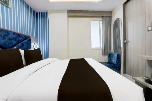 a bedroom with a black and white bed and a window at Hotel O BN RESIDENCY in Ahmedabad