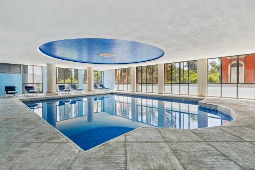 a large swimming pool in a building with a large ceiling at Fiesta Americana Hacienda Ixtapan de La Sal in Ixtapan de la Sal