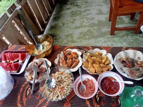 a table topped with lots of different types of food at Azhani Bungalow in Tetebatu
