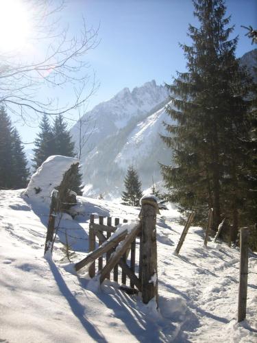 a wooden fence in the snow with a mountain at Apart-Pension Oberreiter in Fusch an der Glocknerstraße