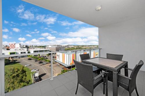 a balcony with a table and chairs and a view of a city at Central Kensington Apartments in Townsville