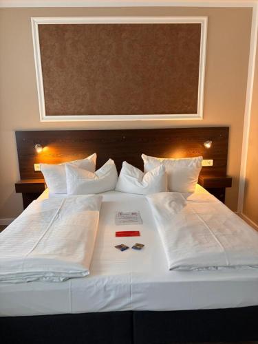 a large bed with white sheets and pillows at Hotel Kiez Pension Berlin in Berlin