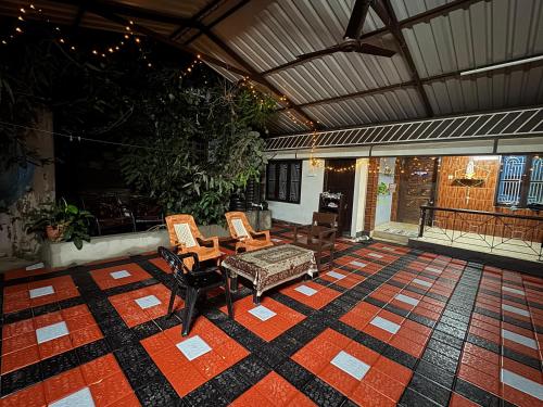 a patio with two chairs and a table on a rug at KENSON'S INN in Mangalore