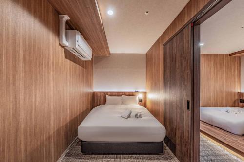 a small room with two beds and a tv at Apartment Hotel 11 Dotonbori4 in Osaka