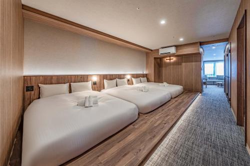 two beds in a hotel room with at Apartment Hotel 11 Dotonbori4 in Osaka