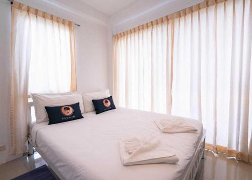 a bedroom with a white bed with two pillows on it at RQ Bangkok Sukhumvit 50 by Collection O in Amphoe Phra Khanong