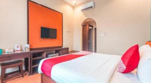 a bedroom with a bed and a desk and a television at Ole Suite Hotel in Bogor