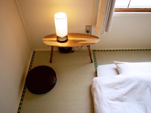 a room with a table and a bed and a candle at Kamifu INN in Kami-furano