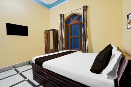 a bedroom with a bed and a window at Hotel O Behror in Neemrana