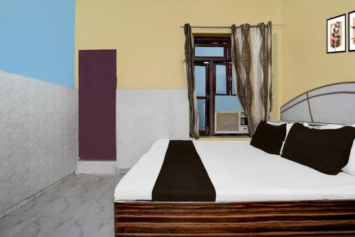 a bedroom with a bed and a window at Hotel O Behror in Neemrana