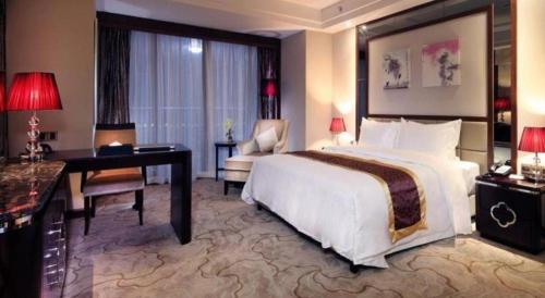 a hotel room with a large bed and a desk at SUN Yat-sen university Hotel and Conference Centre in Guangzhou