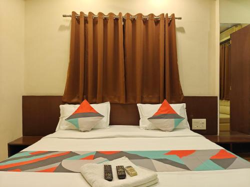 a bed with two remote controls sitting on top of it at Loharkar Hotel in Nagpur