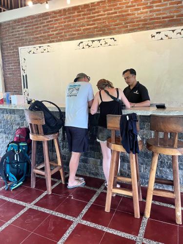 a group of three people standing at a bar at Cersen Resort Lombok in Kuta Lombok