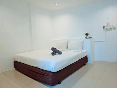 a bed with a black purse sitting on top of it at Ma Non Nont Hotel & Apartment in Nonthaburi