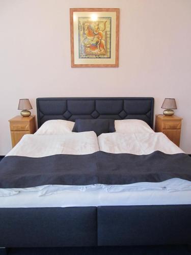 a bedroom with a blue bed with two night stands at Hotel Růžek in Hranice