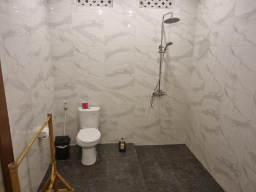 a bathroom with a toilet and a shower at Umah Dewi Private Villa in Ubud