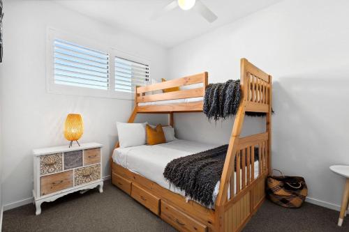 a bedroom with a wooden bunk bed and a desk at Rockpools 3 in Sawtell