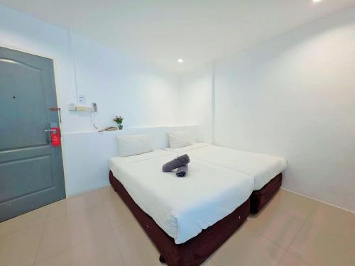 a bedroom with a bed with a hat on it at Ma Non Nont Hotel & Apartment in Nonthaburi