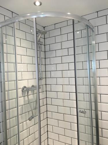 a shower with white subway tiles in a bathroom at Happy Return Hotel in Blackpool