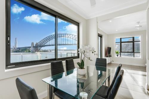a dining room with a view of the sydney harbour at Transcending Views in Sydney