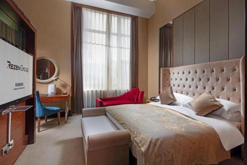 瀋陽市にあるLiaoning Friendship Hotelの大きなベッドと大きな窓のある寝室