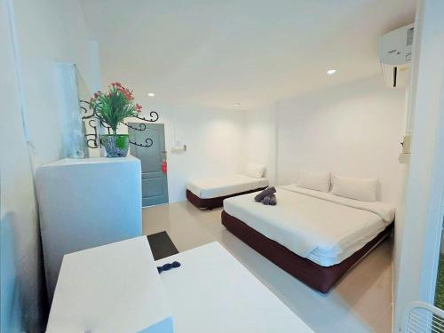 a small room with two beds and a desk at Ma Non Nont Hotel & Apartment in Nonthaburi