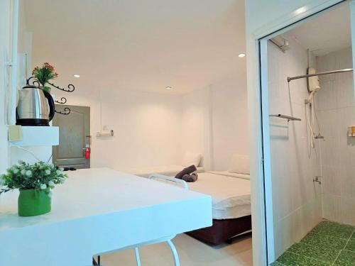 a room with a bed and a table and a mirror at Ma Non Nont Hotel & Apartment in Nonthaburi
