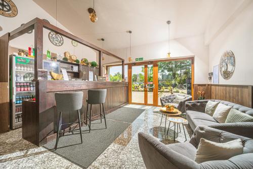 a living room with a couch and a bar at Park Hotel Bükfürdő in Bük