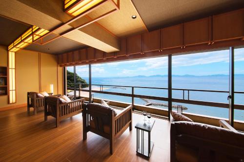 a living room with couches and a view of the ocean at Shunkeiroman Ginpaso in Gamagori
