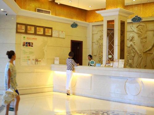 deux personnes debout à un comptoir dans un musée dans l'établissement Vienna Hotel Chengdu Exhibition Center, à Chengdu