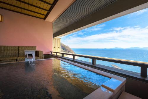 a swimming pool with a view of the ocean at Shunkeiroman Ginpaso in Gamagori