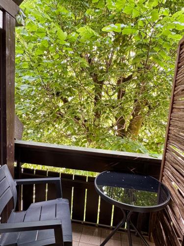 a table and chairs on a balcony with a tree at Apartmaji Lipa in Bohinj