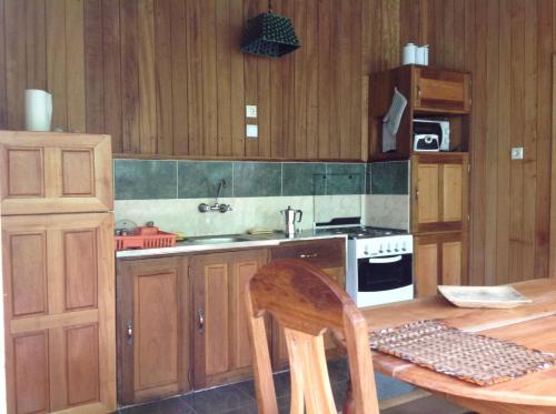 a kitchen with wooden cabinets and a table and a stove at Casa Ediana in Trindade