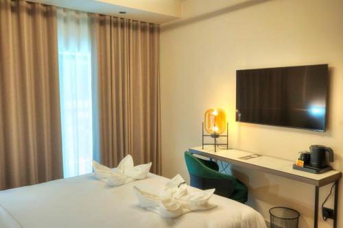 a hotel room with a bed and a desk and a television at ASTE hotel in St Julian's