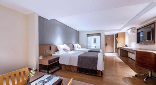 a hotel room with a large bed and a desk at Zhongshan Louis Hotel in Zhongshan