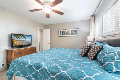 a bedroom with a blue bed and a ceiling fan at Peaceful Lido Island 3Br Walk To Bay, Beach & Shopping By Beachview Rentals in Newport Beach