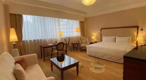 a large hotel room with a bed and a desk at Jianguo Garden Hotel in Beijing