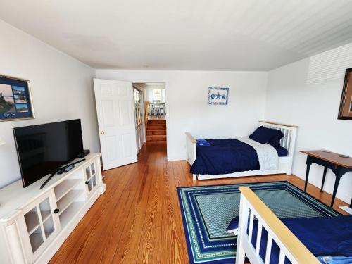 a bedroom with a bed and a flat screen tv at Spacious Oceanfront 3BR Condo with Private Beach in Ideal Hyannis Location in Barnstable