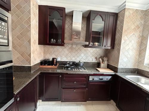 a kitchen with brown cabinets and a sink at Dubai mall Aparment in Dubai