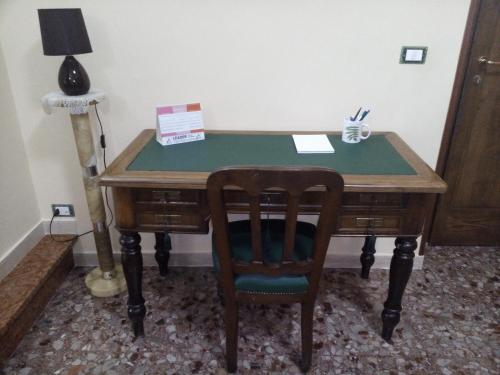 a wooden desk with a chair and a green top at B&B A Casa Di Nonna in Fondi